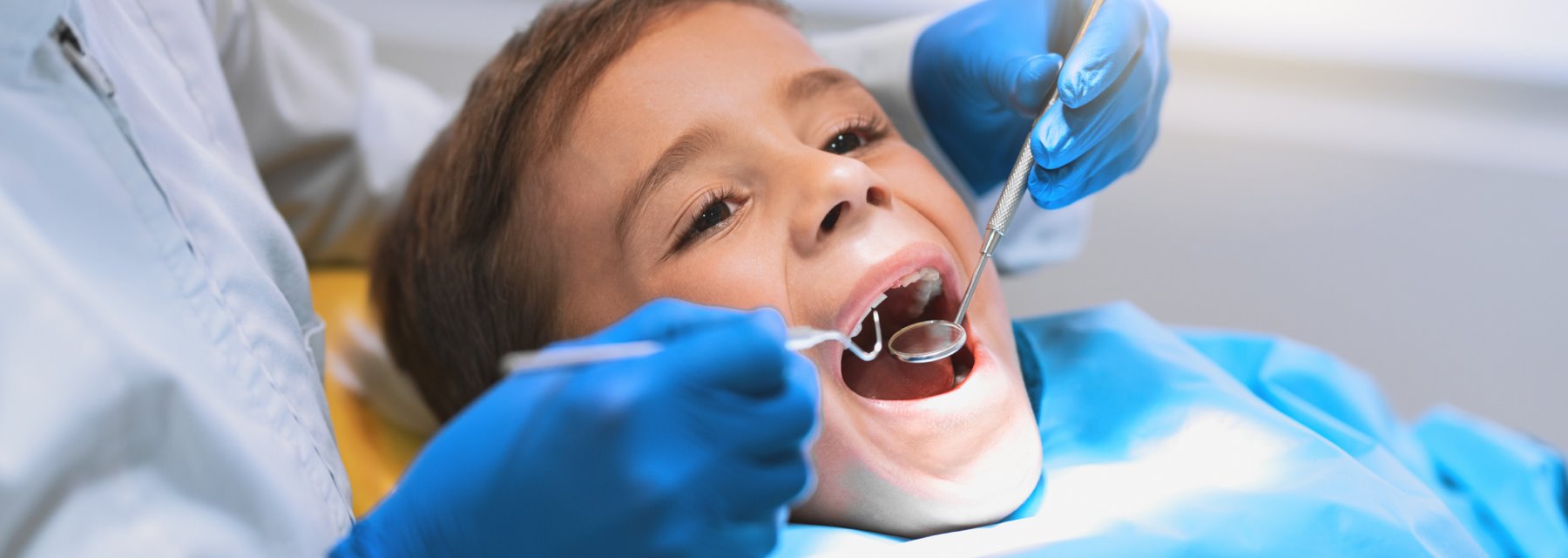 Child sits as dentist examines teeth at Wenatchee Washington